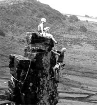 man and woman climb a cliff